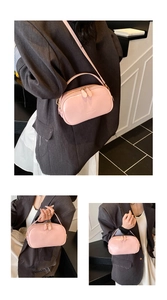 Detail of pink leather handbag showing dual zippers and embossed fashion text logo