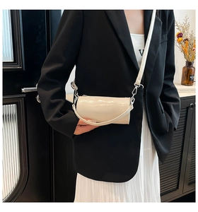 Schicke cremefarbene Zylindertasche aus Ölwachsleder am Modell für urbanen Look