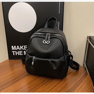 Close-up of black lychee grain leather backpack with silver circular zipper detail