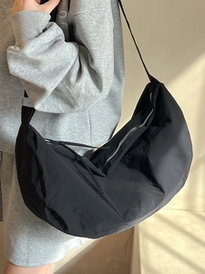 Minimalist black nylon crescent crossbody bag with adjustable wide strap for women