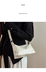 Detail view of the cream tote bag side pocket with a sleek metallic zipper feature