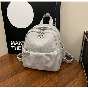 Macro shot of white lychee textured small backpack with silver circular zipper detail