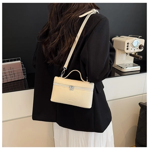 Detailed close-up of cream lychee texture leather bag with silver hardware and zipper