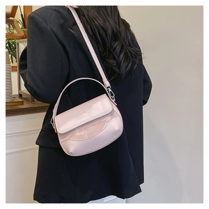 Detail of pink saddle bag with ZIICNMA logo and matte leather stitching on model