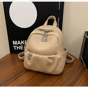 Detail view of apricot litchi texture PU leather mini backpack with silver metal hardware