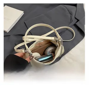 Interior view of cream leather crescent bag showing space for cosmetics and essentials
