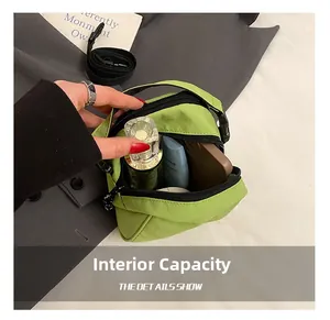 Close-up of the large internal capacity of this green nylon crossbody bag with zipper