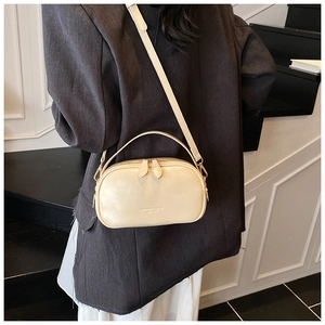 Detail of cream oil wax leather crossbody bag with top handle and gold zipper hardware