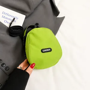 Mini green canvas shell crossbody bag with Lucky label and black shoulder strap