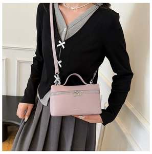 Chic light purple lychee leather box bag worn by model with minimalist styling