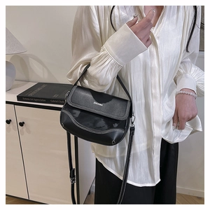 Detail of black leather saddle bag with white stitching and ZHCHMA branding