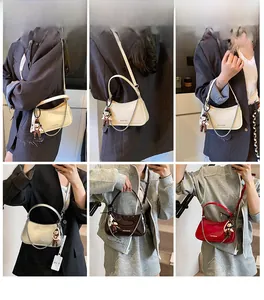 Detail of trendy patent leather shoulder bags in beige, silver, and red with bear charm