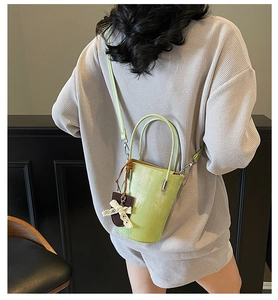 Close-up of light green bucket bag with lace bow detail and detachable strap