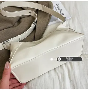 Detailed bottom view of the cream leather tote bag featuring a sturdy rectangular structure