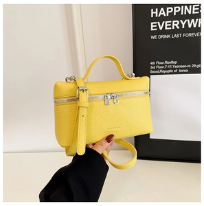 Detailed close-up of bright yellow vanity case bag with pebble leather and silver hardware