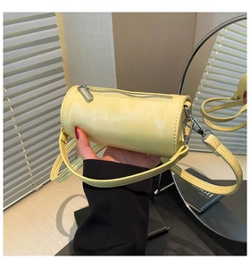 Detailaufnahme der gelben Ölwachs-Zylindertasche mit silbernem Reißverschluss und Riemen