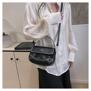 Detail of black leather saddle bag with white contrast stitching and ZHCNMA logo
