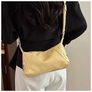 Detail view of cream yellow PU leather tote bag with silver hardware on a model