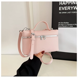 Close-up of pink lychee pattern leather handbag with silver zipper and top handle detail