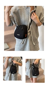 Macro shot of casual black nylon crossbody bag featuring Lucky logo and orange side tag