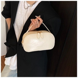 Close-up of minimalist cream white oil wax leather square handbag with dual zip closure