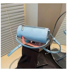 Detail der hellblauen Zylindertasche mit silbernem Reißverschluss und glattem Lederfinish