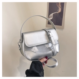 Close-up of silver saddle bag showing sleek metallic finish and detailed stitching