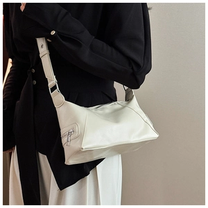 Detail view of cream white leather tote showing silver zipper pocket and smooth texture