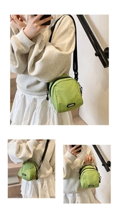 Detail of green canvas crossbody bag with LUCKY patch and adjustable black strap