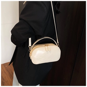 Macro shot of milk white oil wax leather handbag with double zipper and gold logo
