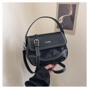 Close-up of black saddle bag featuring white contrast stitching and ZHCNMA logo detail