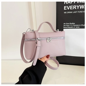 Detailed macro view of lilac purple lychee texture leather handbag with dual zipper closure