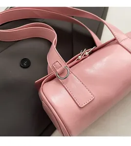 Close-up of pink baguette bag showing fine faux leather texture and silver buckle detail