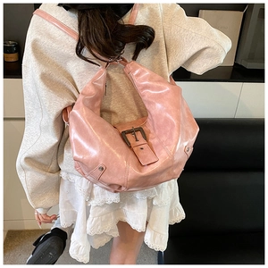 Detail view of the pink faux leather moon bag with retro buckle and rivet accents