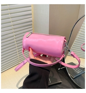 Detailansicht der glänzenden rosafarbenen Zylindertasche aus Lackleder mit Reißverschluss