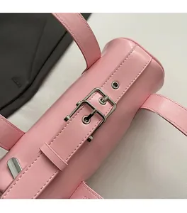 Close-up of pink leather handbag showing silver buckle and precise stitching detail