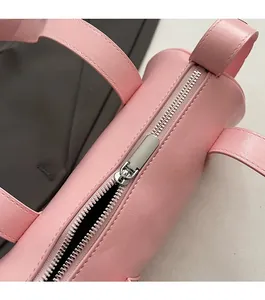Detail of pink PU leather baguette bag featuring a smooth silver metal zipper and neat stitching