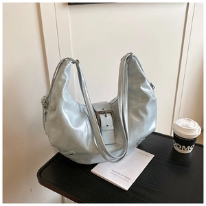 Detail shot of a light blue crescent hobo bag with glossy finish and metal buckle decoration