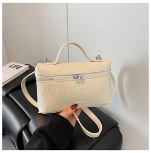 Close-up of cream lychee texture leather handbag with silver double zipper detail