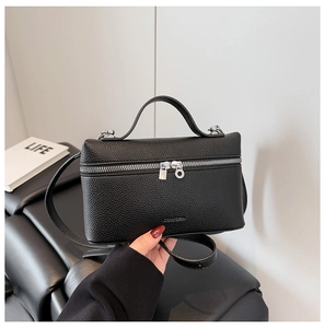 Close-up of black lychee grain leather crossbody bag with silver double zipper and handle