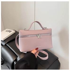 Detail of light purple lychee texture leather handbag with silver zipper and handle
