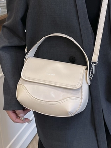 Minimalist cream saddle bag with top handle and crossbody strap for modern women