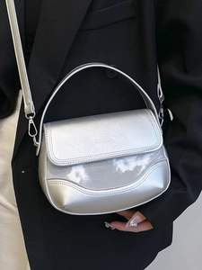 Metallic silver saddle handbag with wavy texture and adjustable strap for women
