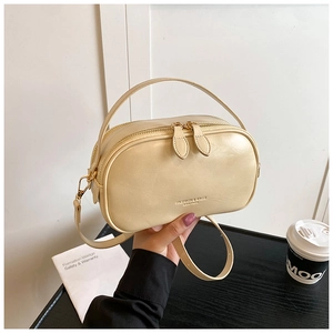Close-up of cream oil wax leather handbag with golden zipper and fashion logo details