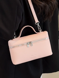 Pink lychee texture crossbody bag with silver hardware worn by a model in a sleek style