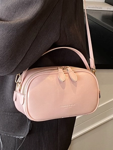 Pink faux leather square handbag with dual zippers shown as a crossbody bag