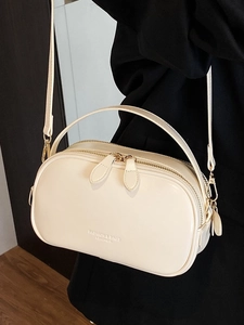 Chic cream leather crossbody bag with dual zippers and minimalist rectangular shape