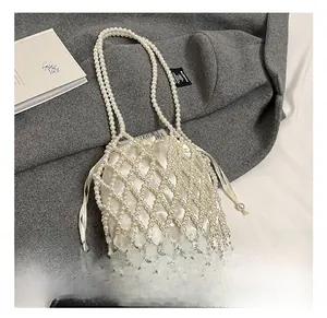 Détail du sac à main en perles blanches avec une pochette élégante en satin assorti