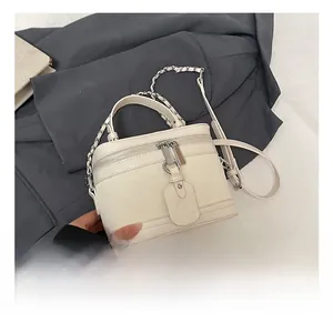 Detail of white box bag featuring quilted weave texture and silver chain strap