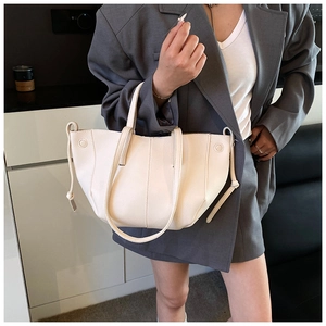 Close-up of minimalist off-white lychee texture leather tote bag with drawstring detail